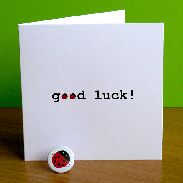 card saying good luck with ladybirds replacing letter o - and a ladybird badge